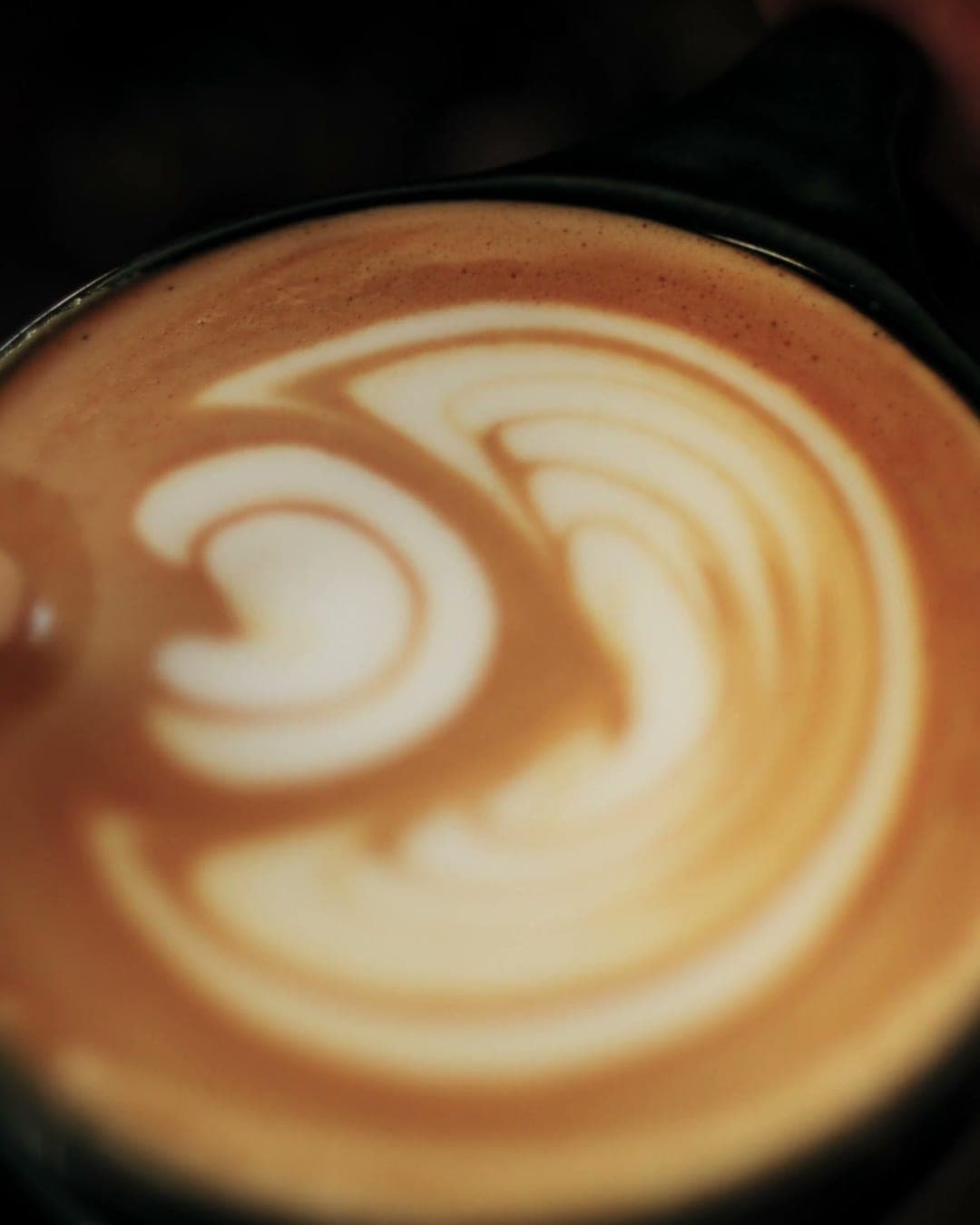 Milk poured into an espresso, forming latte art.
