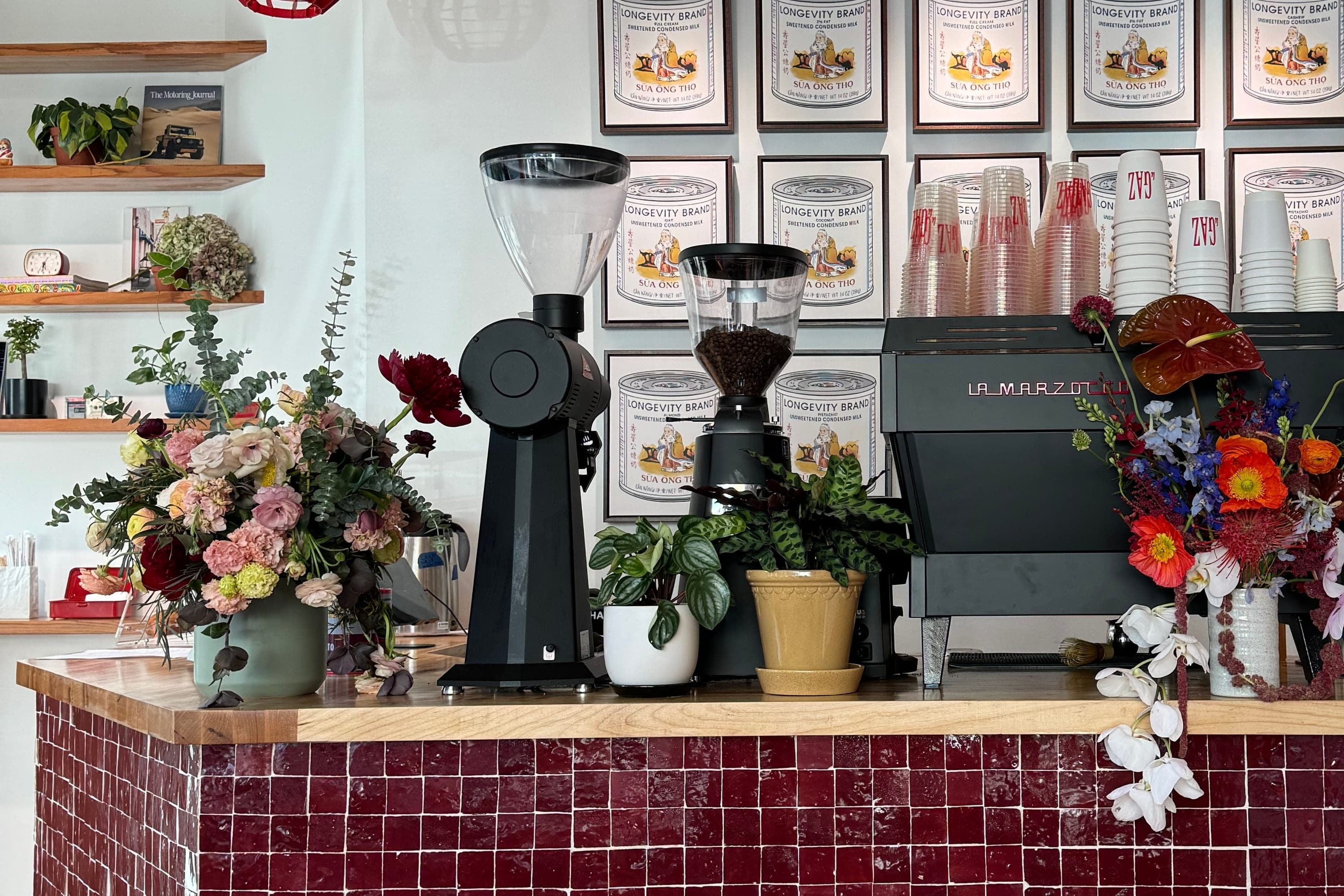 The bar at Cafe Le Gaz in New York, with its grinders, espresso machine and red tiled counter.